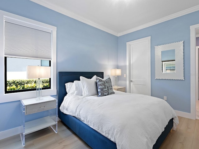 bedroom featuring ornamental molding and light hardwood / wood-style flooring