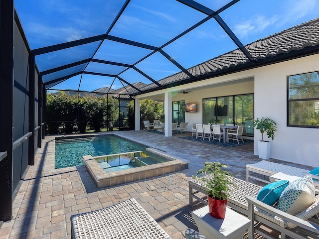 view of swimming pool featuring an in ground hot tub, ceiling fan, a lanai, and a patio area