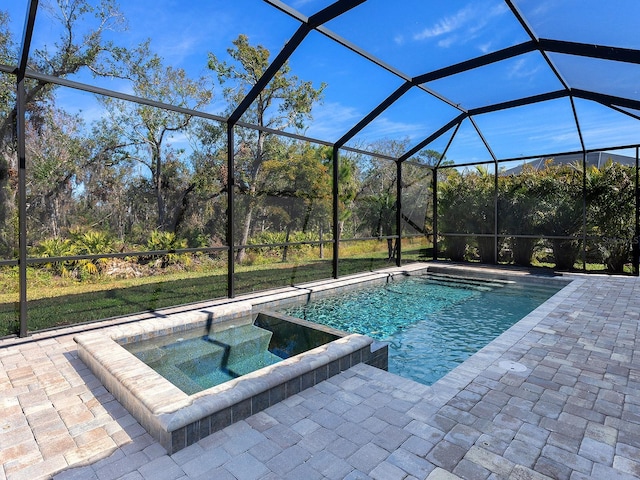 view of swimming pool with an in ground hot tub, a lanai, and a patio