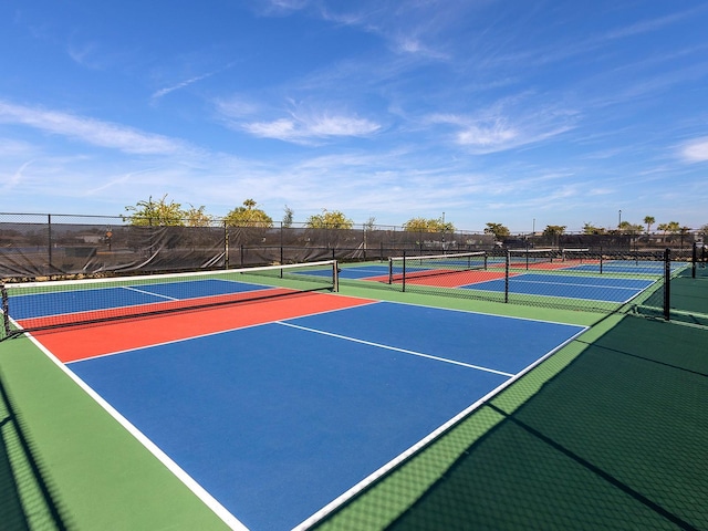 view of tennis court featuring community basketball court and fence