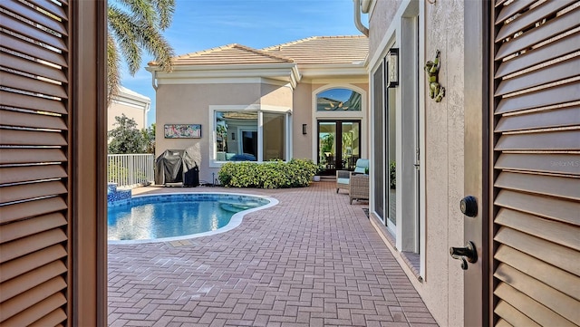 view of pool featuring a patio area and french doors