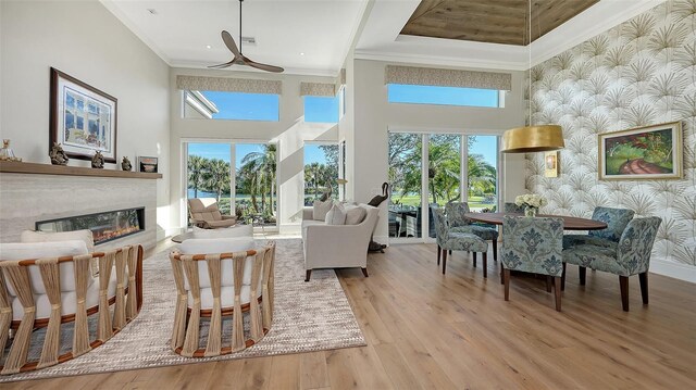 interior space featuring a high ceiling, ornamental molding, and light wood-type flooring