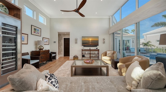 living room with ornamental molding, a healthy amount of sunlight, and light wood-type flooring