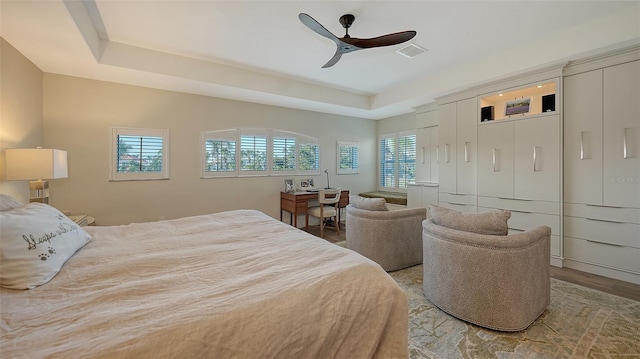 bedroom featuring a tray ceiling, light hardwood / wood-style flooring, and ceiling fan