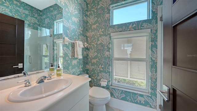 bathroom featuring vanity, toilet, and an enclosed shower