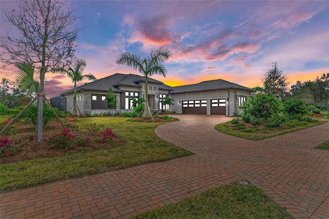 prairie-style home with a garage and a lawn