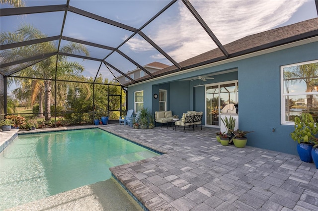 view of pool featuring a lanai, a patio area, outdoor lounge area, and ceiling fan