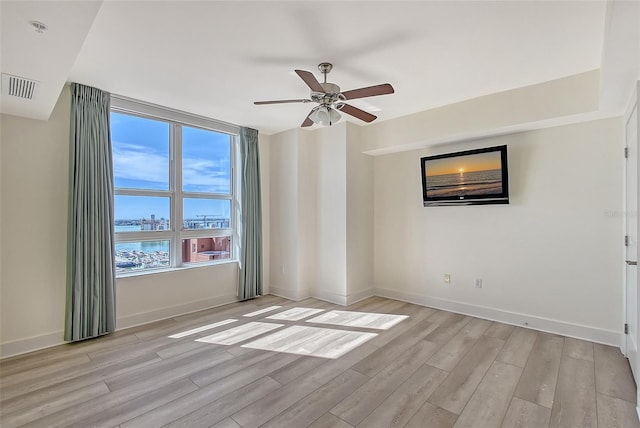 empty room with light hardwood / wood-style floors and ceiling fan