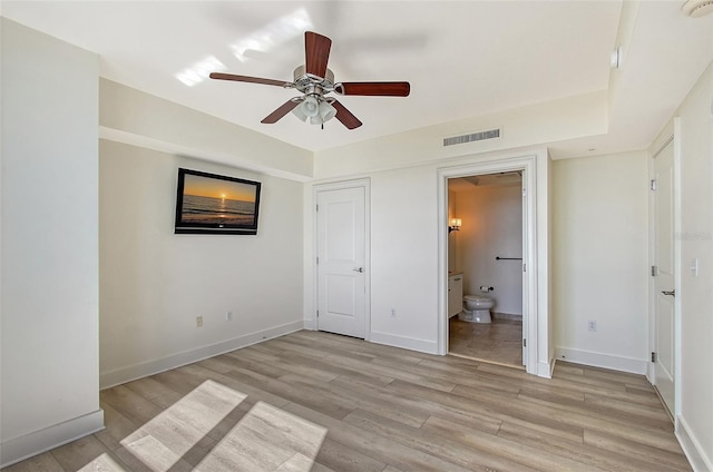 unfurnished bedroom with connected bathroom, light hardwood / wood-style flooring, and ceiling fan