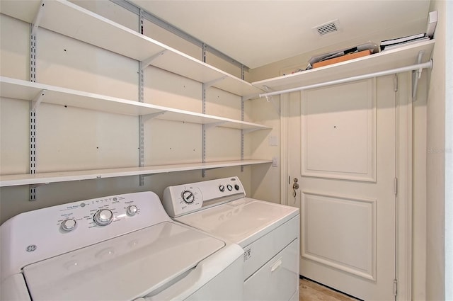 clothes washing area featuring separate washer and dryer