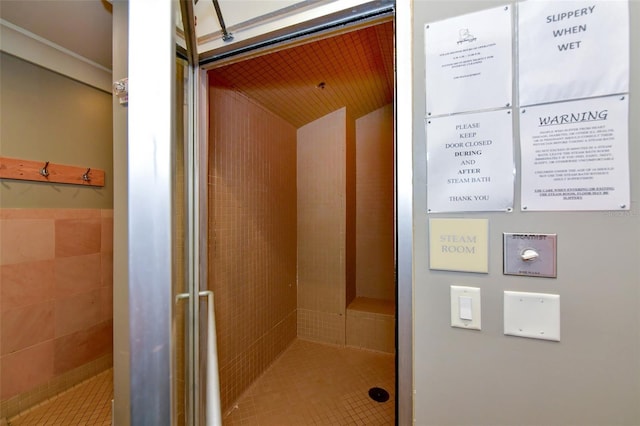 bathroom with tile walls, a mail area, and tiled shower