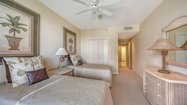 carpeted bedroom featuring ceiling fan and a closet