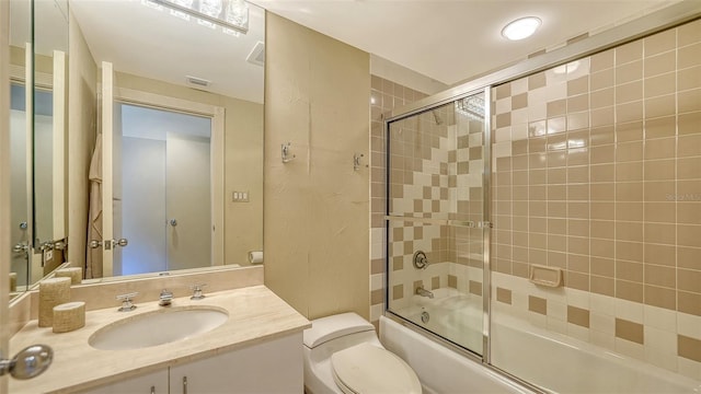 full bathroom featuring enclosed tub / shower combo, vanity, and toilet