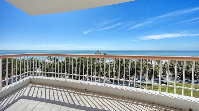 balcony with a water view and a view of the beach