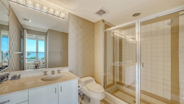 bathroom featuring vanity, toilet, an enclosed shower, and tile walls