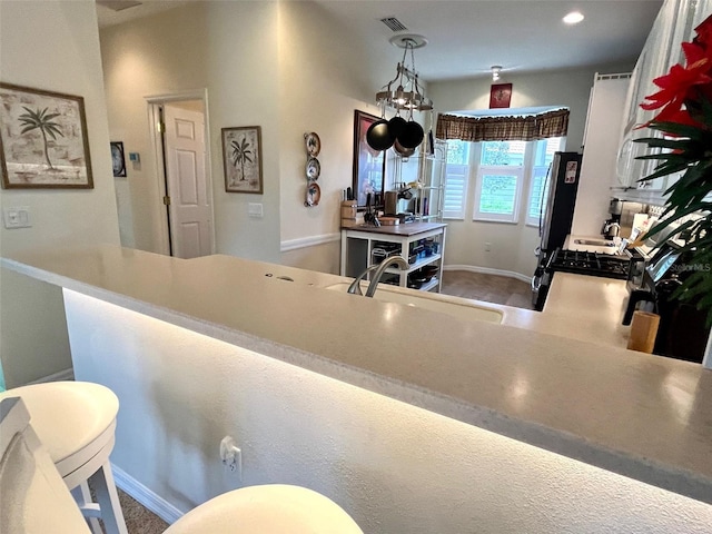 kitchen with appliances with stainless steel finishes, sink, a kitchen breakfast bar, and kitchen peninsula