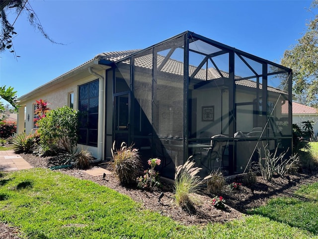 view of property exterior featuring glass enclosure