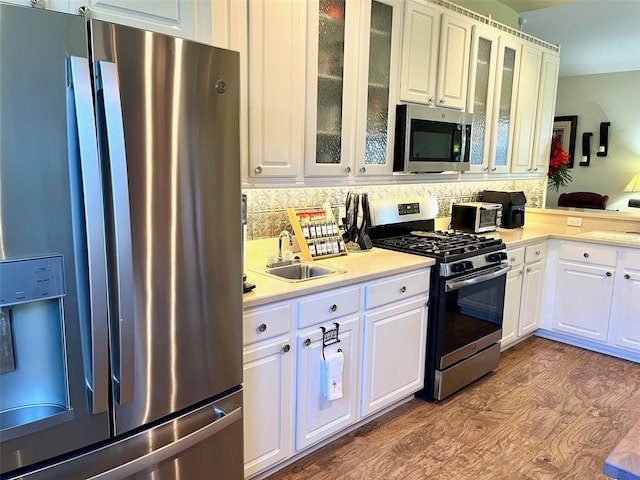 kitchen featuring white cabinetry, stainless steel appliances, sink, tasteful backsplash, and dark hardwood / wood-style floors