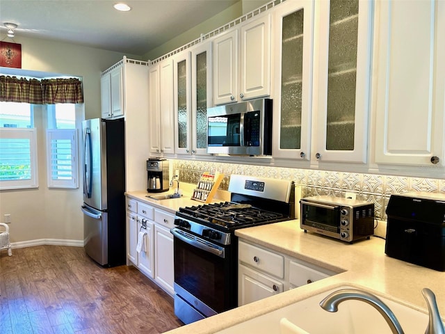 kitchen with white cabinetry, dark hardwood / wood-style floors, tasteful backsplash, and stainless steel appliances