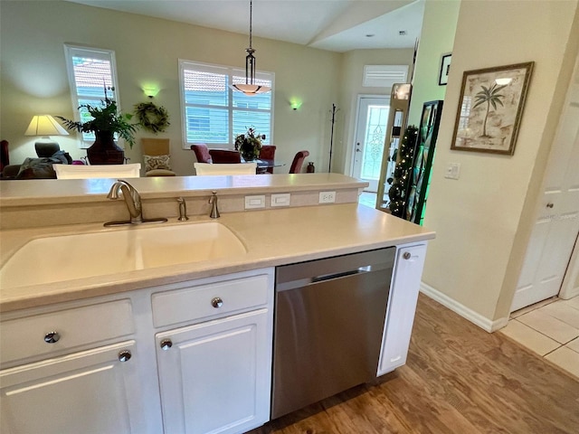 kitchen with dishwasher, decorative light fixtures, a wealth of natural light, sink, and white cabinetry