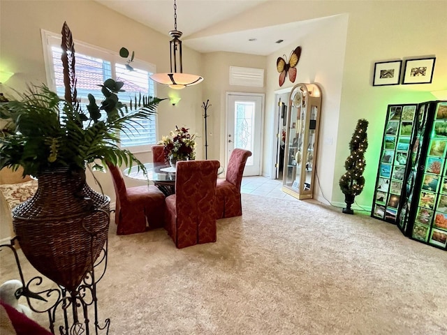 carpeted dining space featuring high vaulted ceiling and plenty of natural light