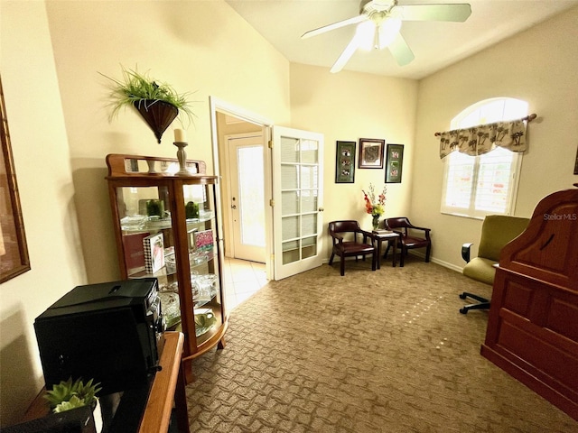 living area with ceiling fan and light colored carpet