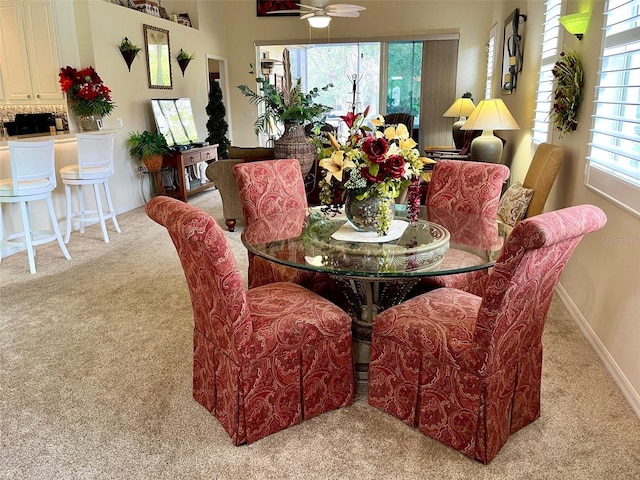 carpeted dining space with ceiling fan