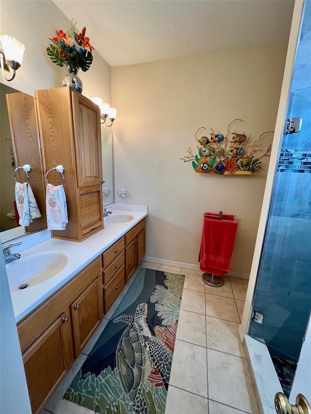 bathroom with a textured ceiling, vanity, tile patterned flooring, and a shower