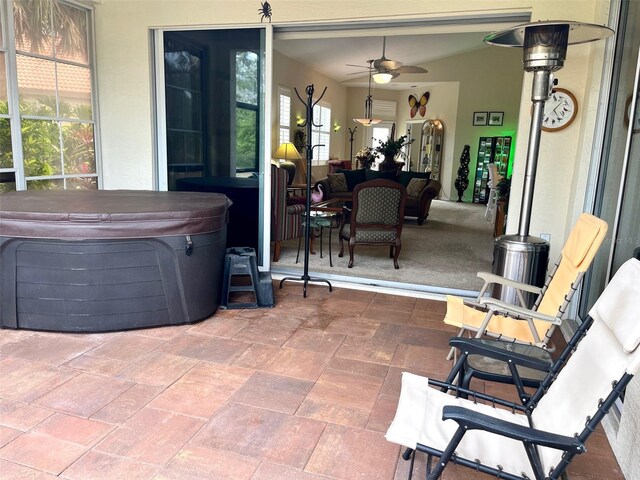 view of patio / terrace featuring ceiling fan and a hot tub