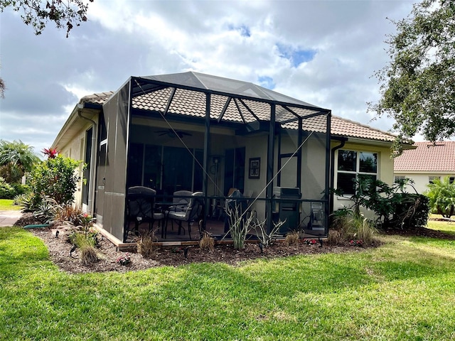 rear view of property with a yard, a lanai, and a patio area