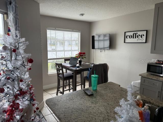 tiled dining area with a textured ceiling and a wealth of natural light