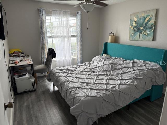 bedroom with ceiling fan and dark hardwood / wood-style flooring