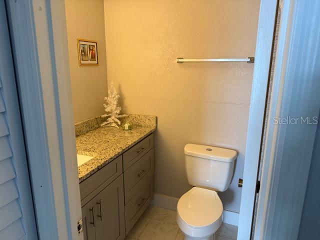 bathroom featuring tile patterned flooring, vanity, and toilet