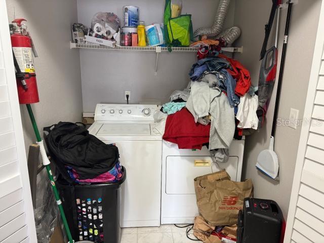 washroom with washer and dryer and light tile patterned flooring