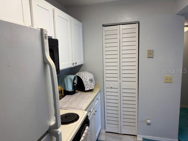 kitchen with white cabinetry and white appliances