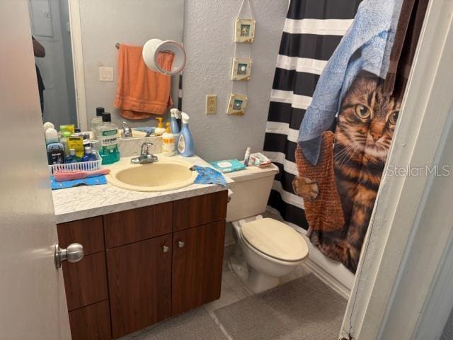 bathroom with vanity, tile patterned flooring, toilet, and walk in shower