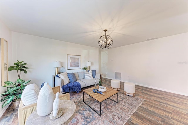 living room with hardwood / wood-style floors and a notable chandelier