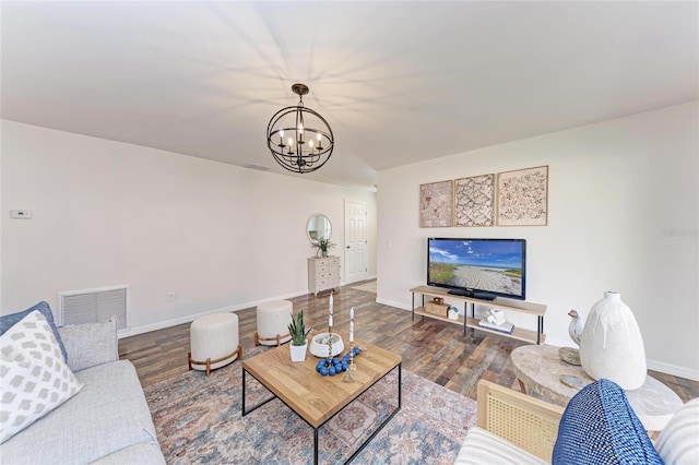 living room with dark wood-type flooring and a chandelier