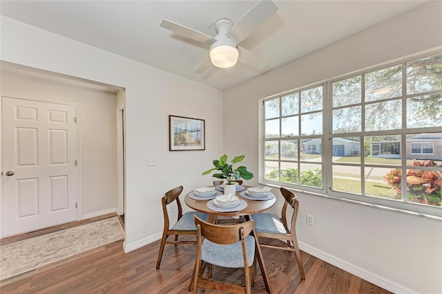 dining space with dark wood-type flooring and ceiling fan