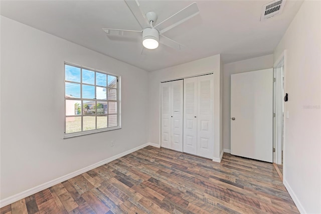 unfurnished bedroom featuring ceiling fan, dark hardwood / wood-style flooring, and a closet