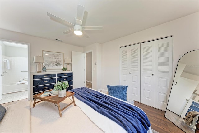 bedroom with ensuite bath, dark wood-type flooring, a closet, and ceiling fan