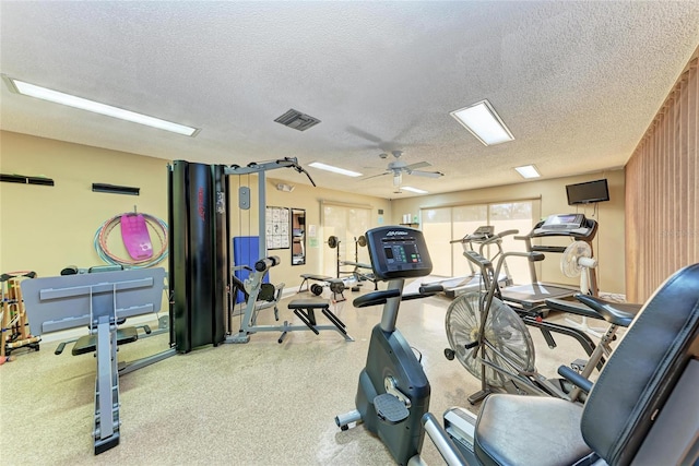 workout area featuring ceiling fan and a textured ceiling