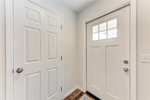 doorway featuring dark wood finished floors and baseboards