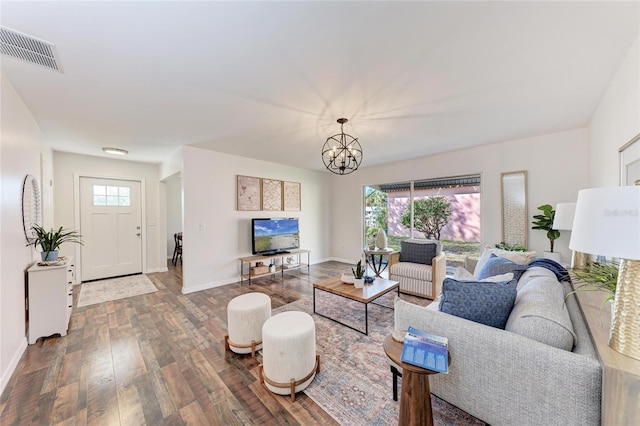 living area featuring baseboards, a notable chandelier, visible vents, and wood finished floors