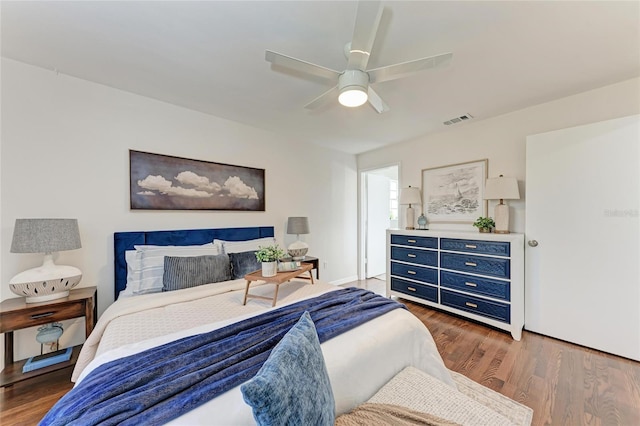 bedroom with ceiling fan, wood finished floors, and visible vents