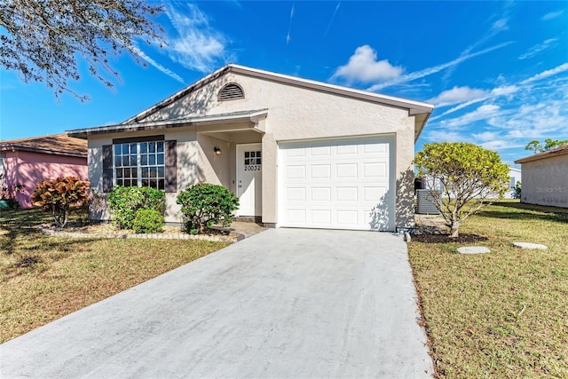 single story home featuring a garage, a front yard, concrete driveway, and stucco siding