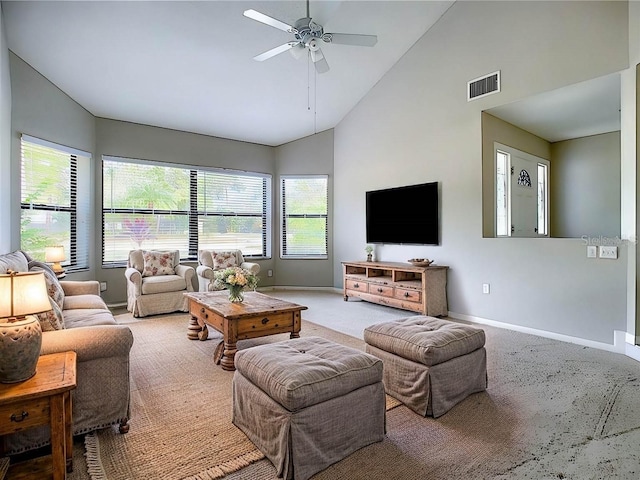 carpeted living room with ceiling fan and high vaulted ceiling