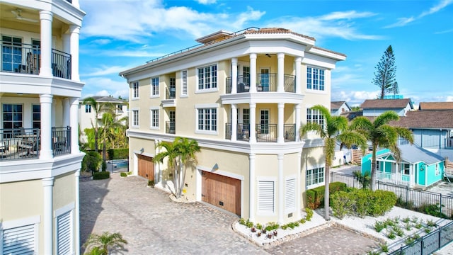 greek revival inspired property with a garage and a balcony