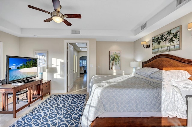 bedroom featuring a raised ceiling and ceiling fan