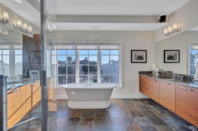 bathroom featuring vanity, separate shower and tub, and a healthy amount of sunlight